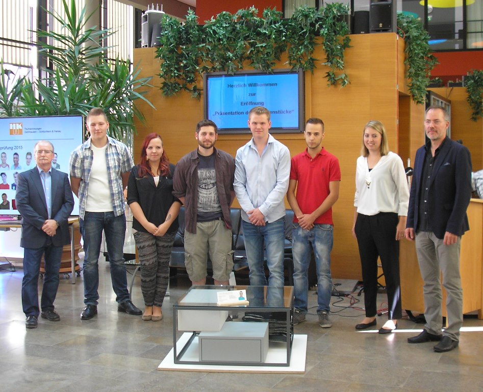 Die Prämierten und Belobigten mit der Jury sowie dem Sieger des Wettbewerbs "Die gute Form", Manuel Basermann (im roten T-Shirt), vor dem Siegerstück "Couchtisch".