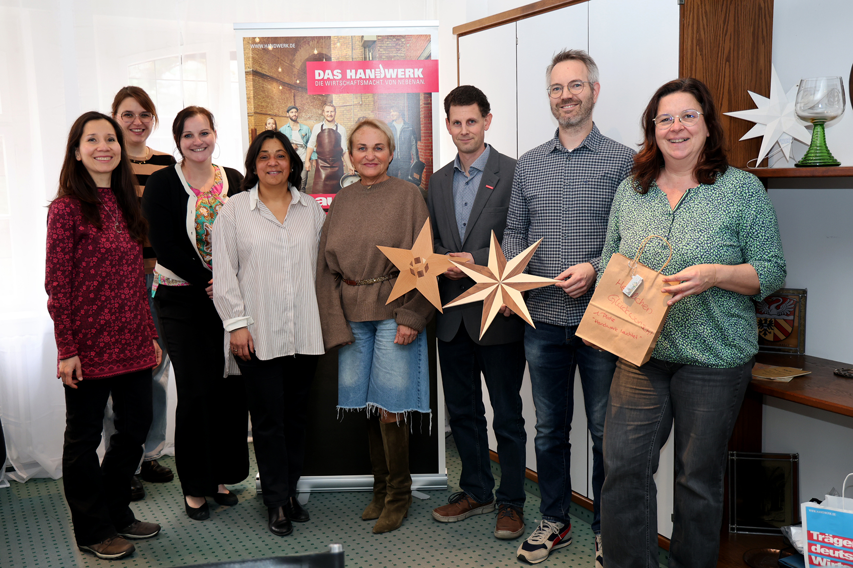 Preis&uuml;bergabe f&uuml;r die Tischler der Kinzig-Schule und ihre Sterne (von rechts): Simone Gr&uuml;newald, Benjamin Franz, Holger Faust, Esther Hummel, Sheila Eckert, Anett Kuykendall, Eva Kessler und Maria Schnepp. Foto: Stadt Gelnhausen
